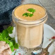 sesame ginger dressing in glass jar with spoon next to it