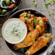 Buffalo Turkey Wings in a round grey dish with bleu cheese dressing