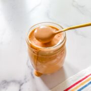 Everything sauce in glass jar with gold spoon