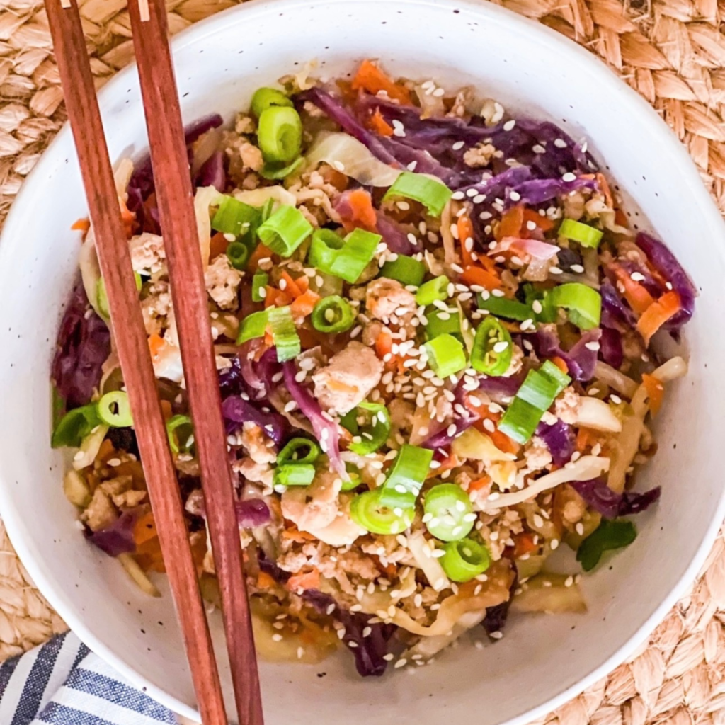 egg roll in a bowl in round white bowl with chop sticks