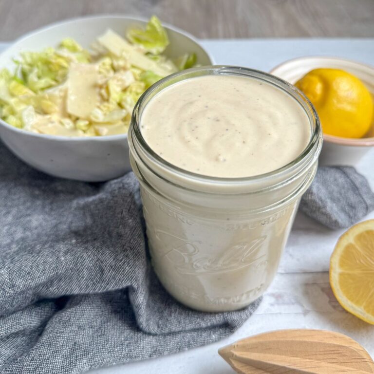Caesar Dressing in ball jar with lemons and salad