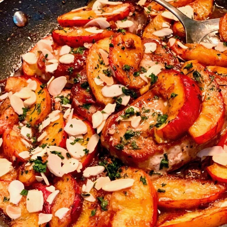 pork and peaches in fry pan with serving spoon