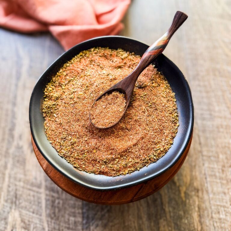 Cajun seasoning in black dish with wooden spoon