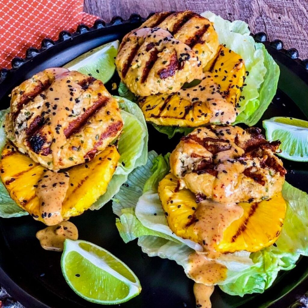Grilled Teriyaki Chicken Burgers (with Pineapple) on black round plate