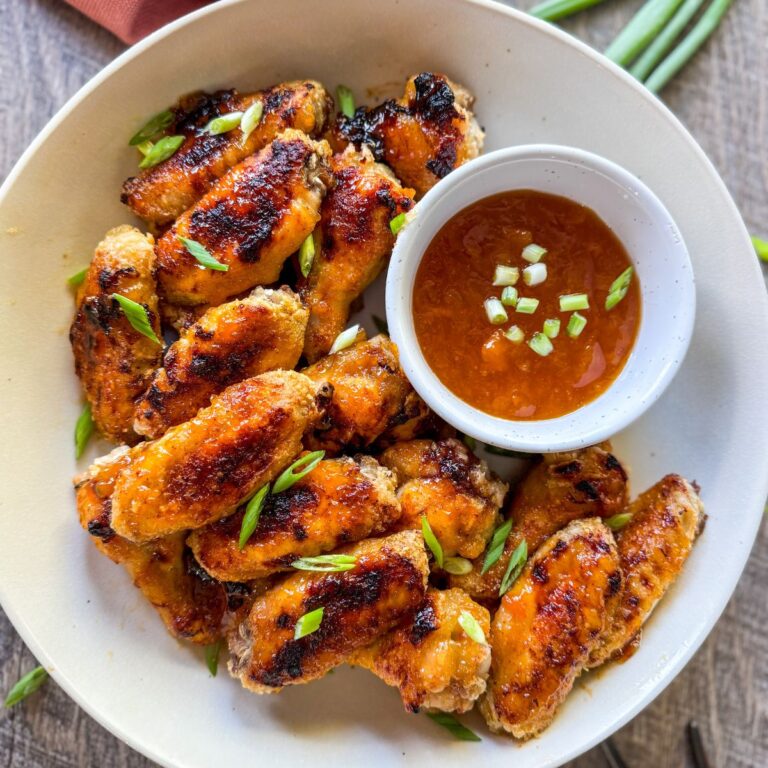 hot honey. peach wings in round white bowl with peach dipping sauce