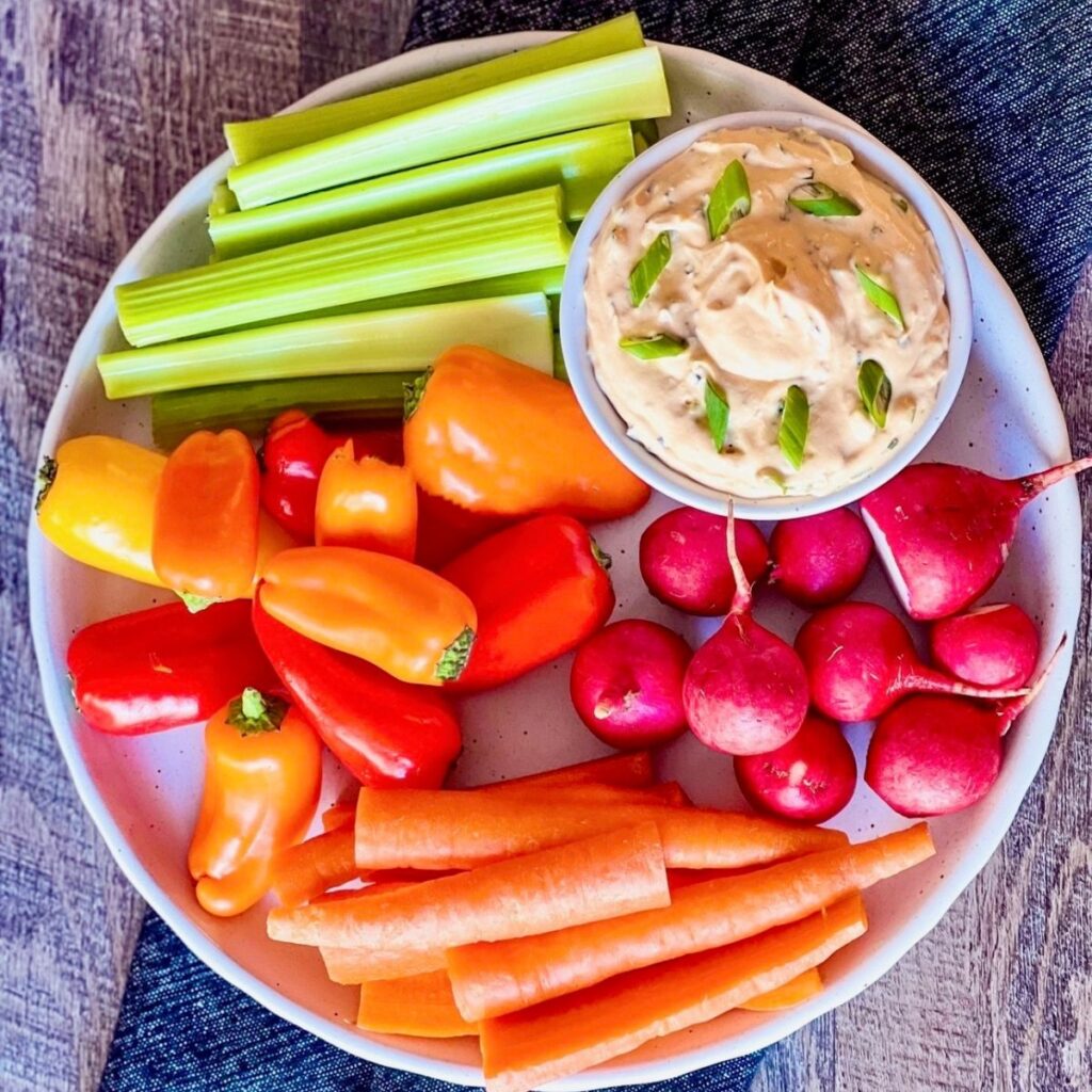 buffalo cream cheese dip in round dish with fresh veggies