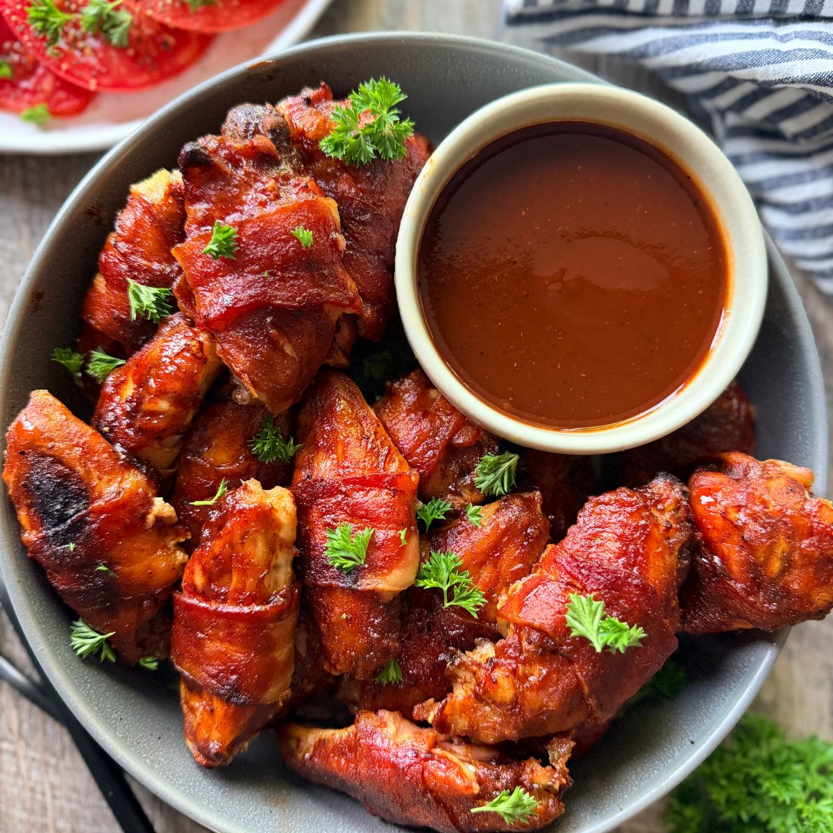 bacon wrapped chicken wings with sweet and spicy bbq sauce with extra sauce for dipping
